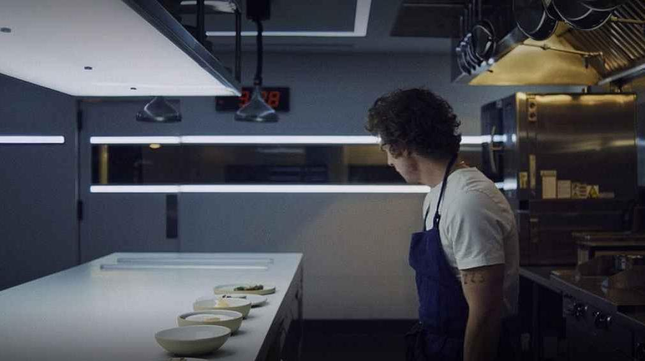 Carmy stands in front of a counter full of new dishes